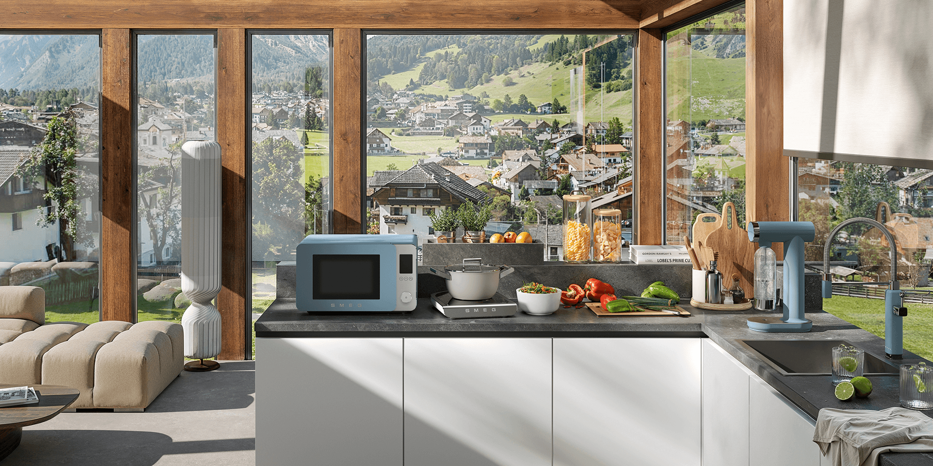 Contemporary kitchen with large floor-to-ceiling windows overlooking a green landscape, featuring SMEG appliances and accessories with storm blue accents on a central island, surrounded by dark cabinetry, wood ceilings, and natural light.