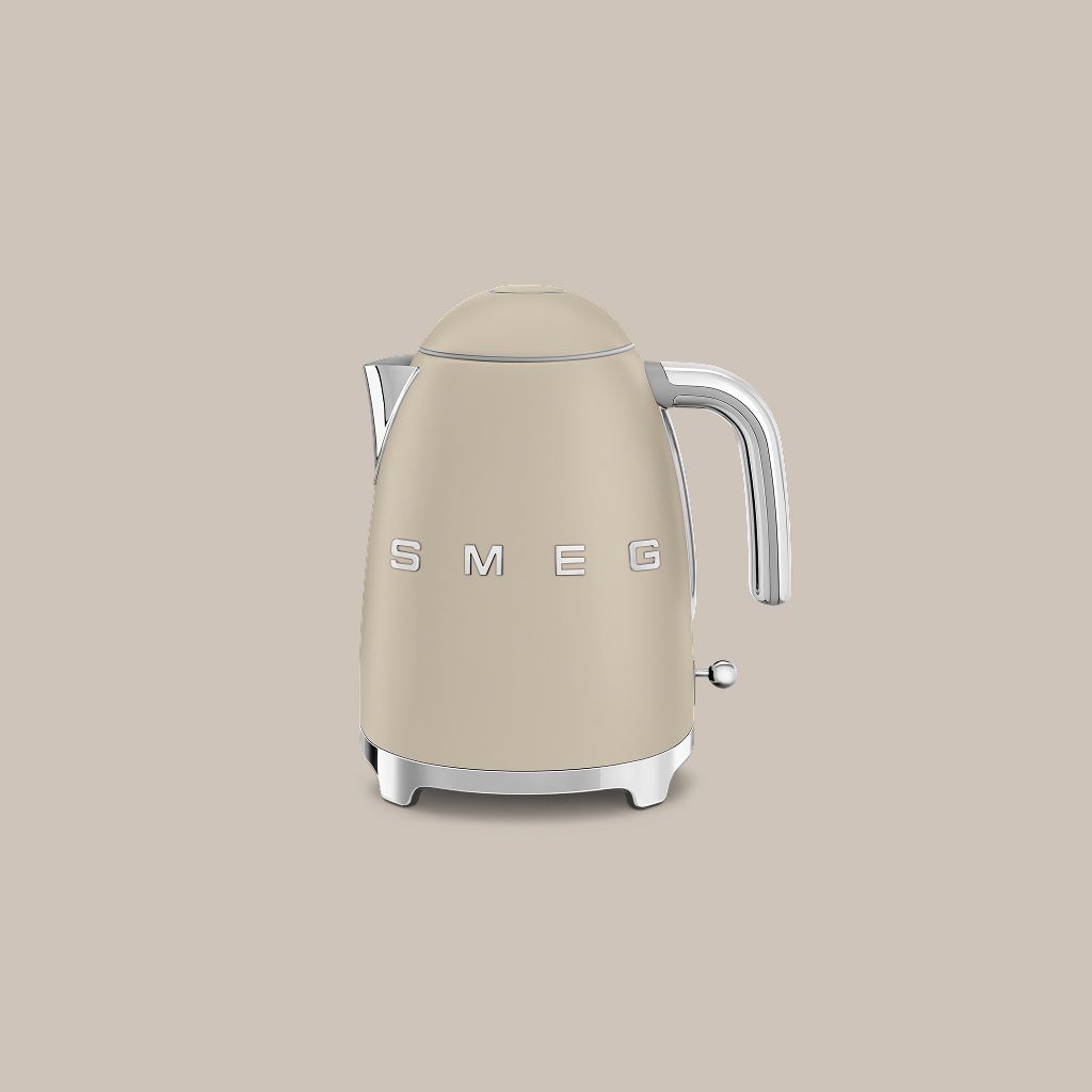 A Moonlight Smeg 50s Style kettle with chrome accents sits on a textured stone block against a neutral wall