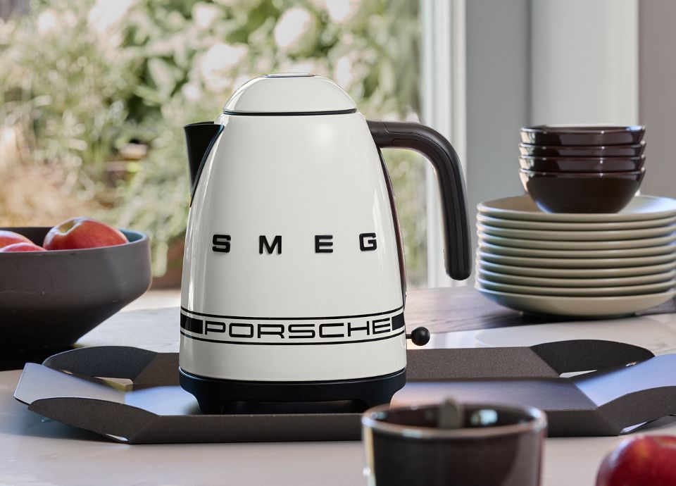 KLF03PCWAU Carrara White Porsche x SMEG kettle in a kitchen surrounded by kitchen utensils