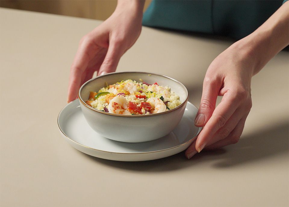 The final dish is ready to be eaten with two hands placing it on the table