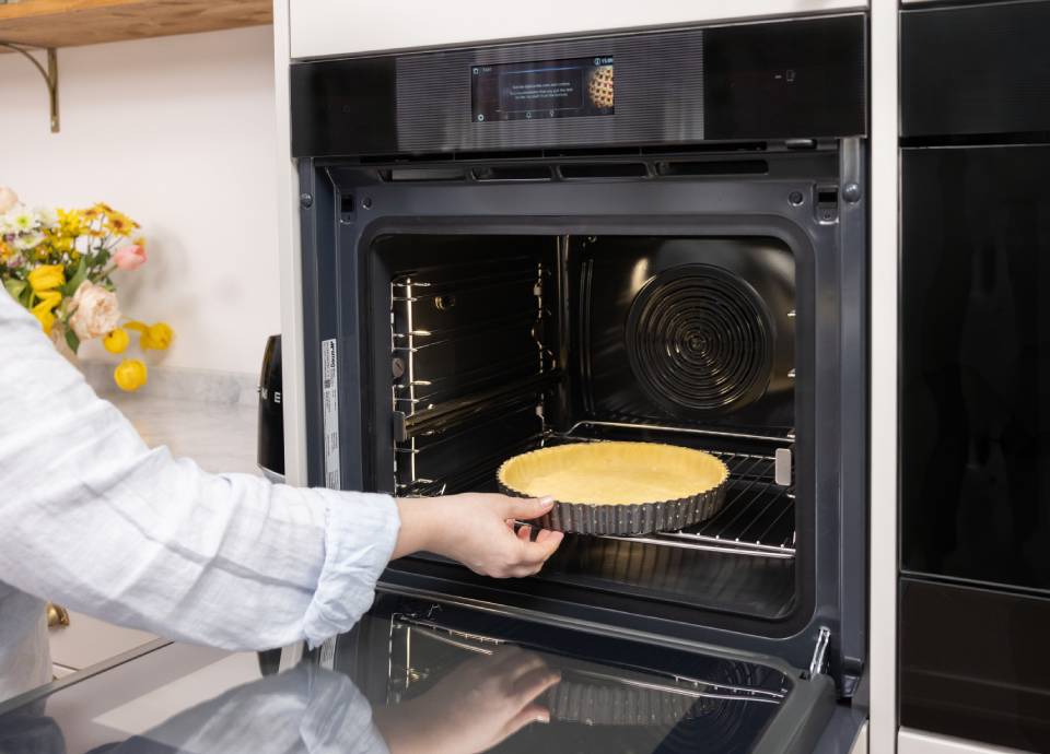 Placing tart crust into an oven for baking