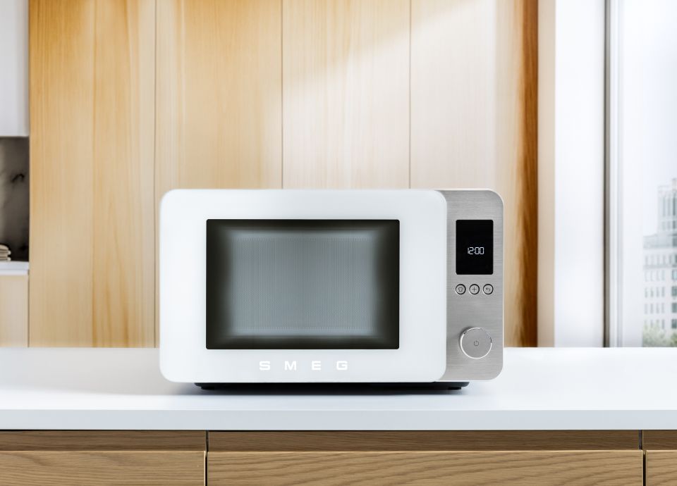 White MOC02 Microwave on a white countertop in a light wood kitchen.