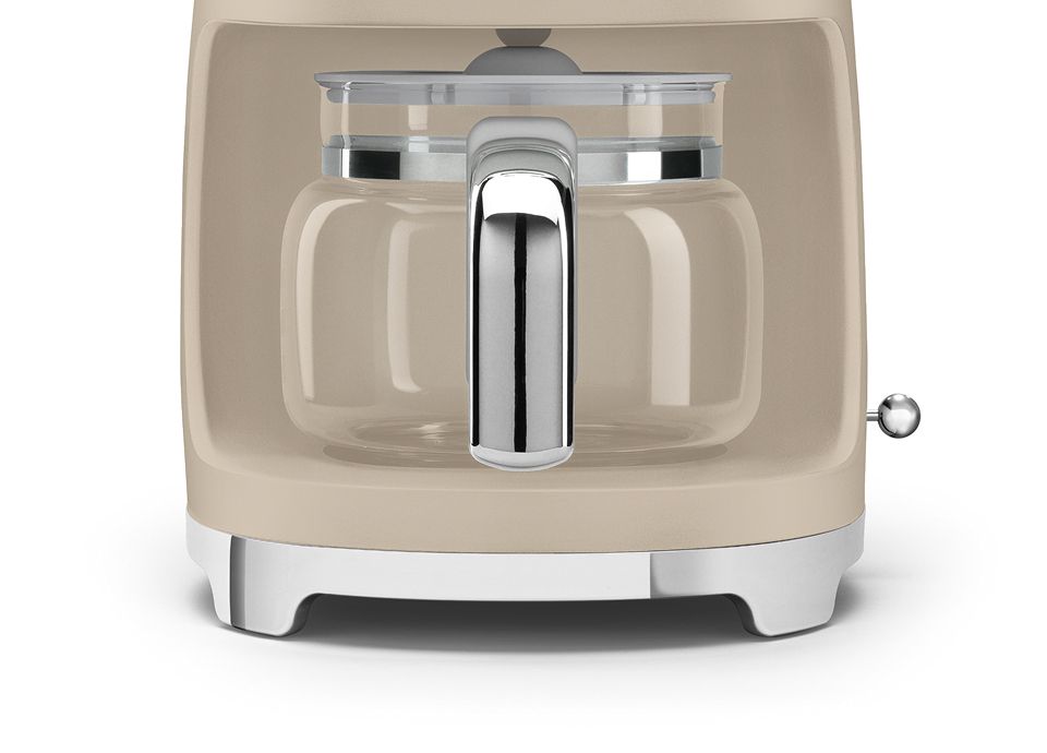 Close-up da jarra em vidro com pega em cromado, integrada na base da máquina de café Moonlight com acabamento mate.